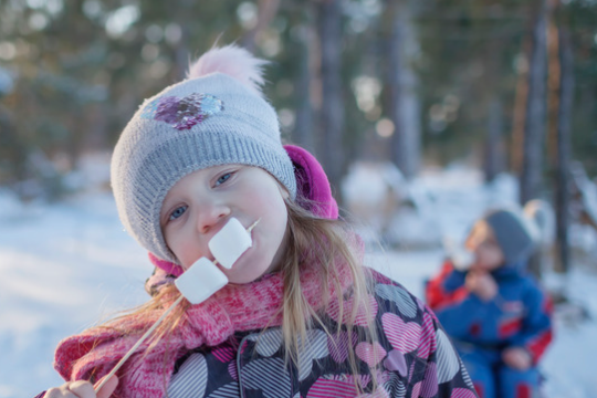 a little girl eating a donut
