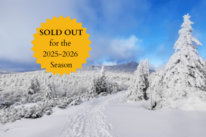 Snowy landscape with evergreen trees, blue sky, and 'SOLD OUT for the 2025-2026 Season' badge.