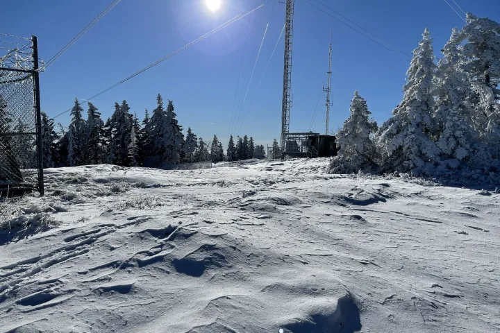 a man flying through the air on a snow covered slope